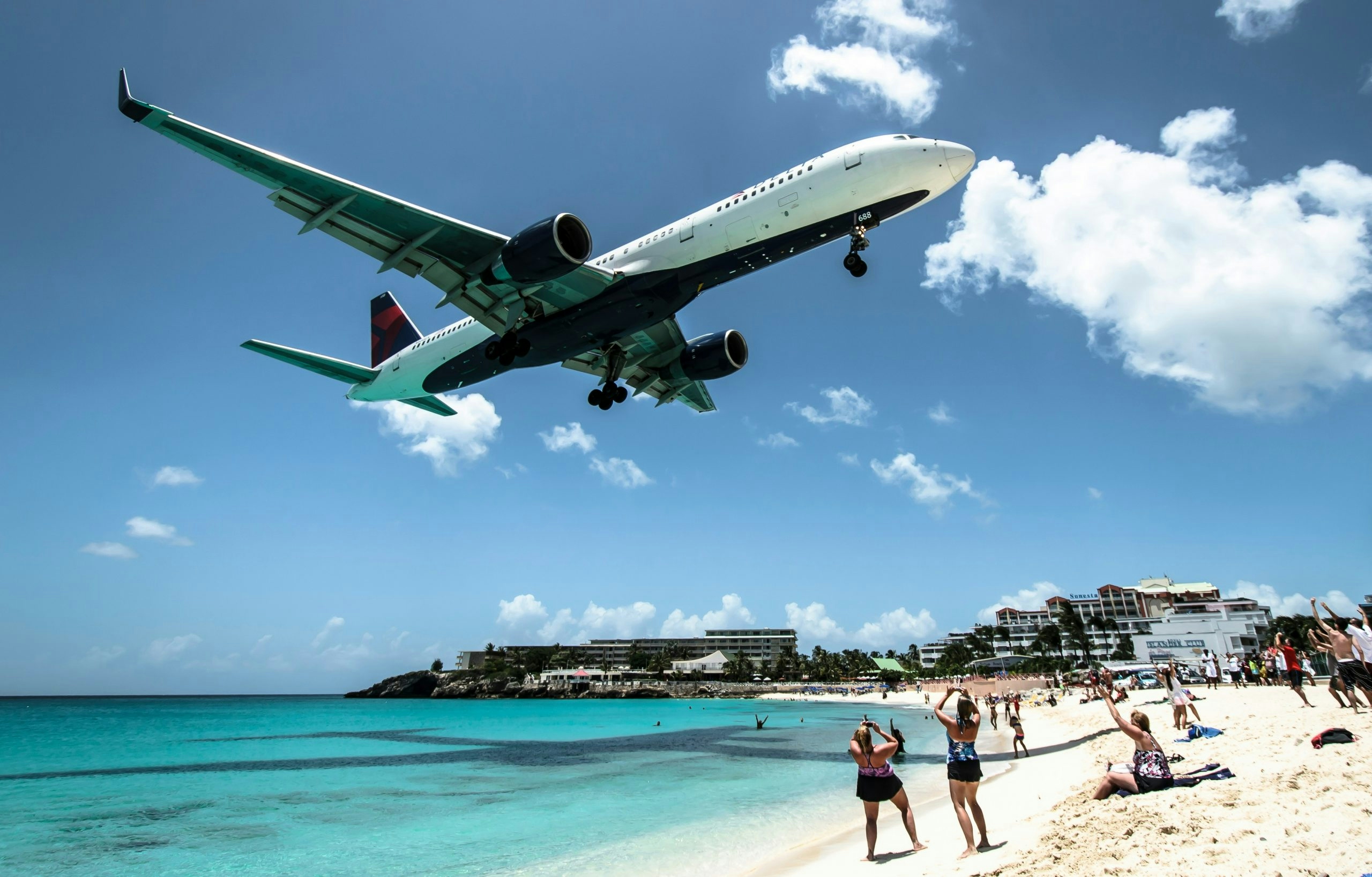 Airplane flying low over a tropical beach in St. Maarten