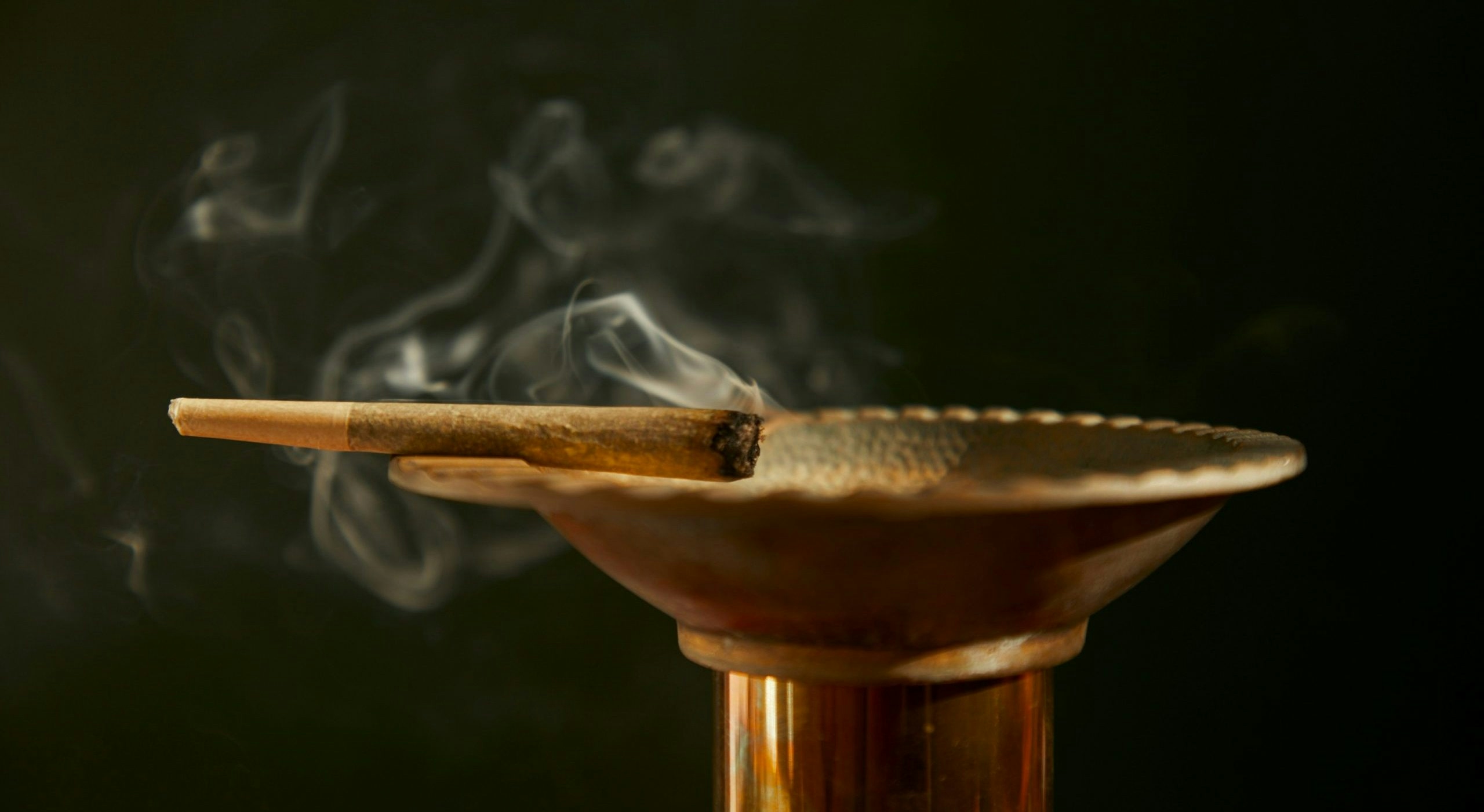 A lit joint sitting on a bowl-shaped tray.