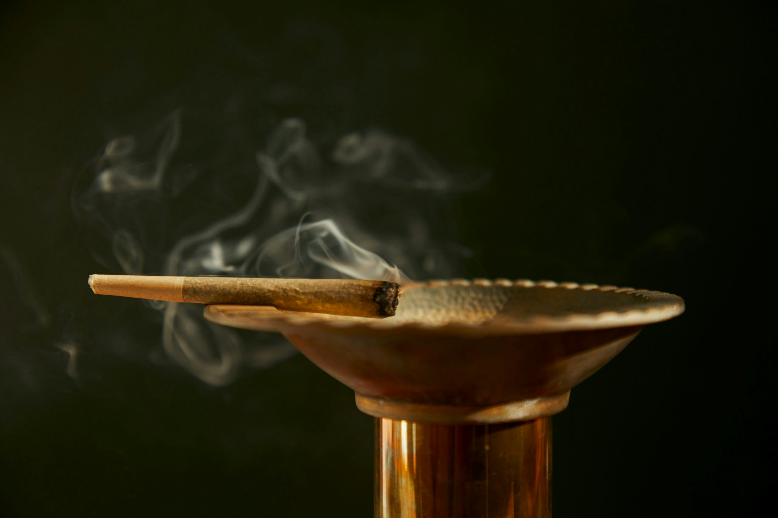 A lit joint sitting on a bowl-shaped tray.
