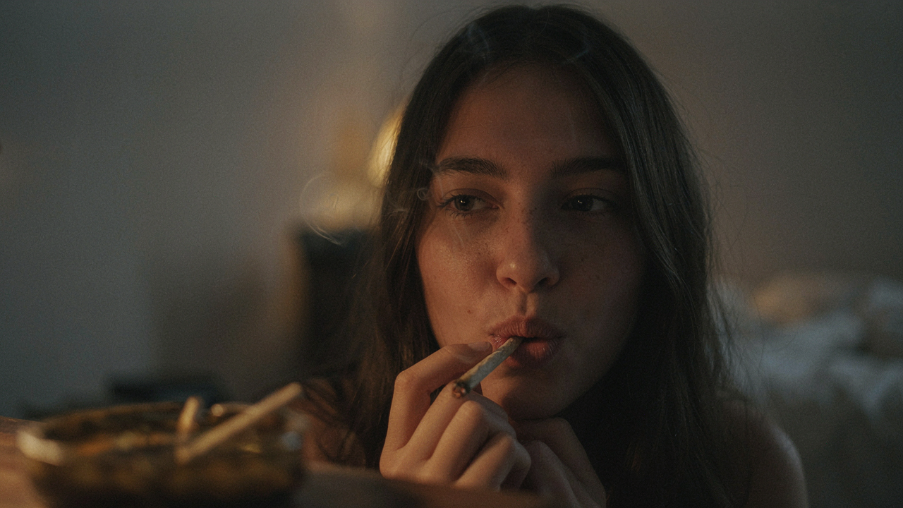 woman inhaling a joint with her eyes closed.
