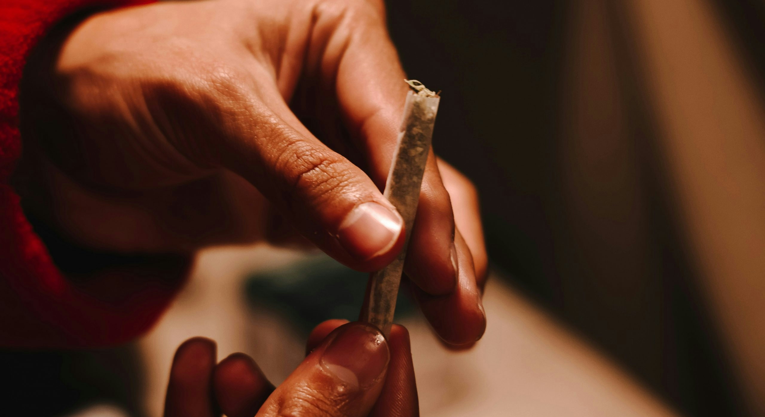 Two hands sealing a weed joint closed.