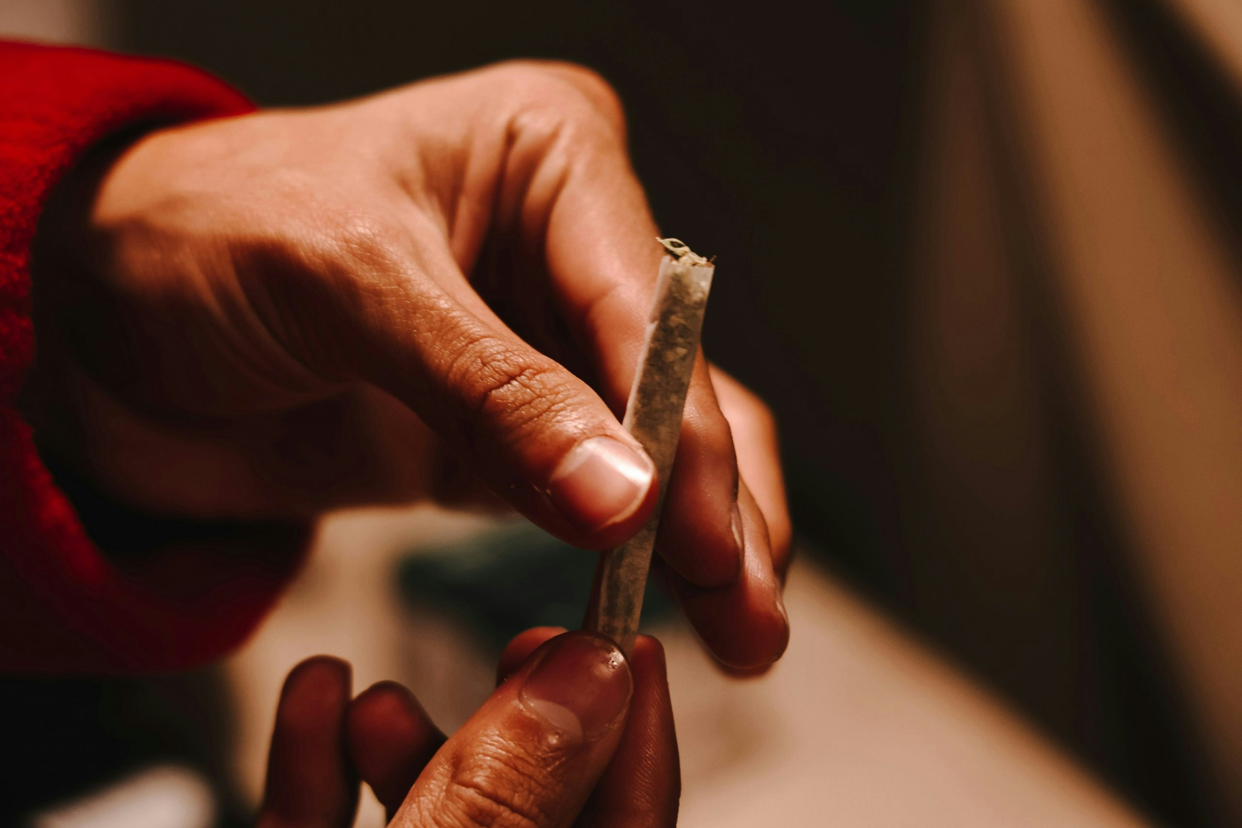Two hands sealing a weed joint closed.