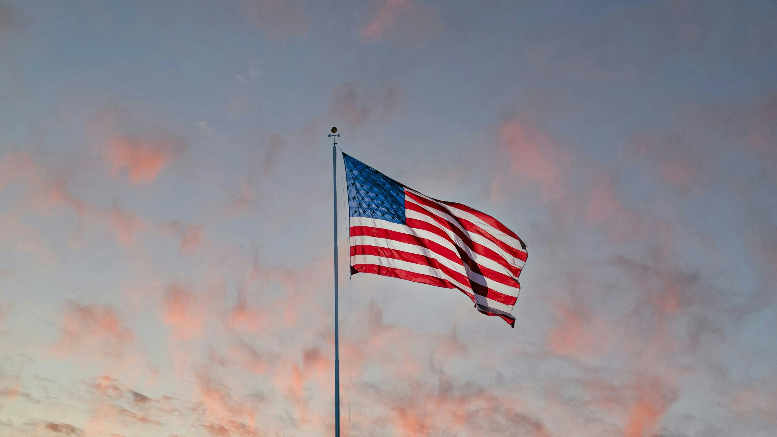 United States national flag displayed behind a beutiful sky