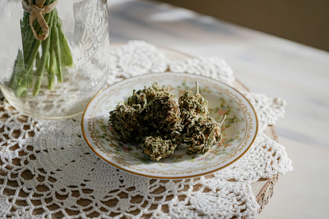 Multiple cannabis flower buds displayed on a ceramic plate