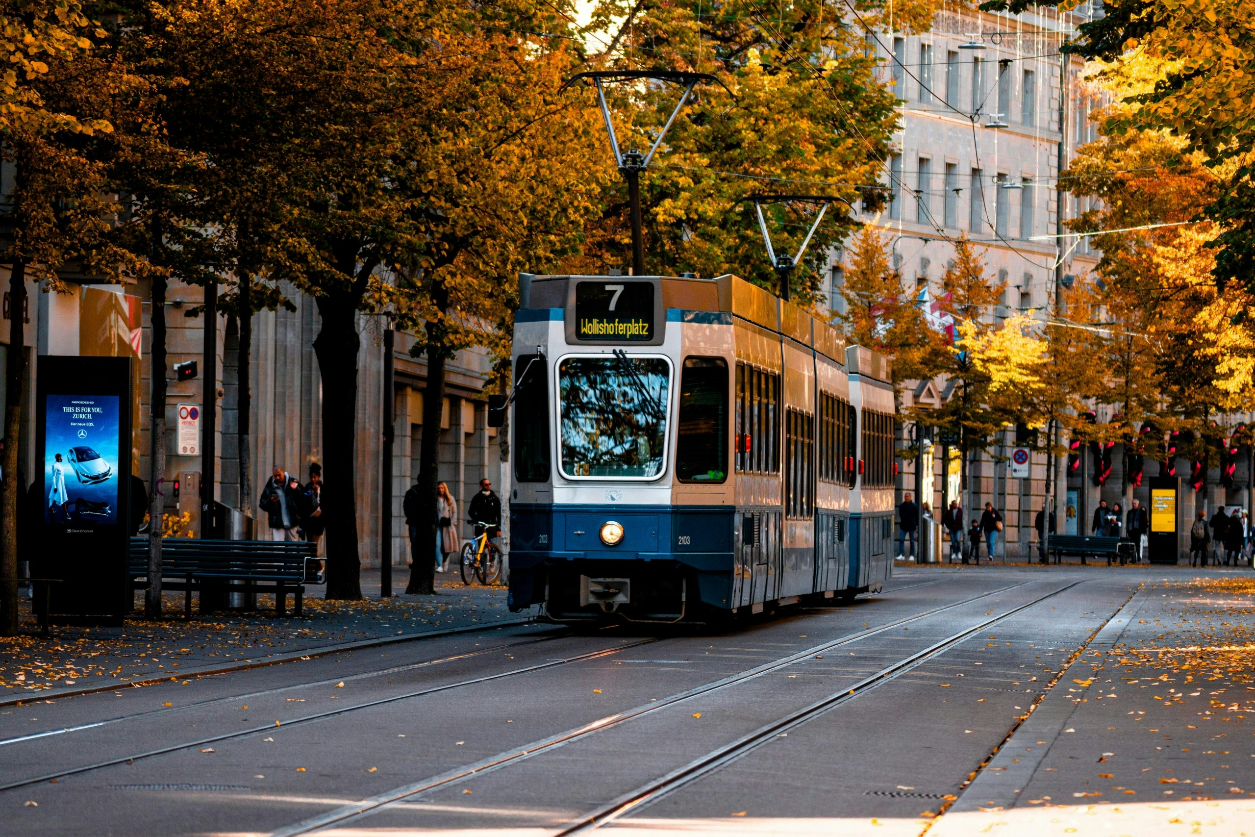 Red tram traveling through a busy street in central Zurich