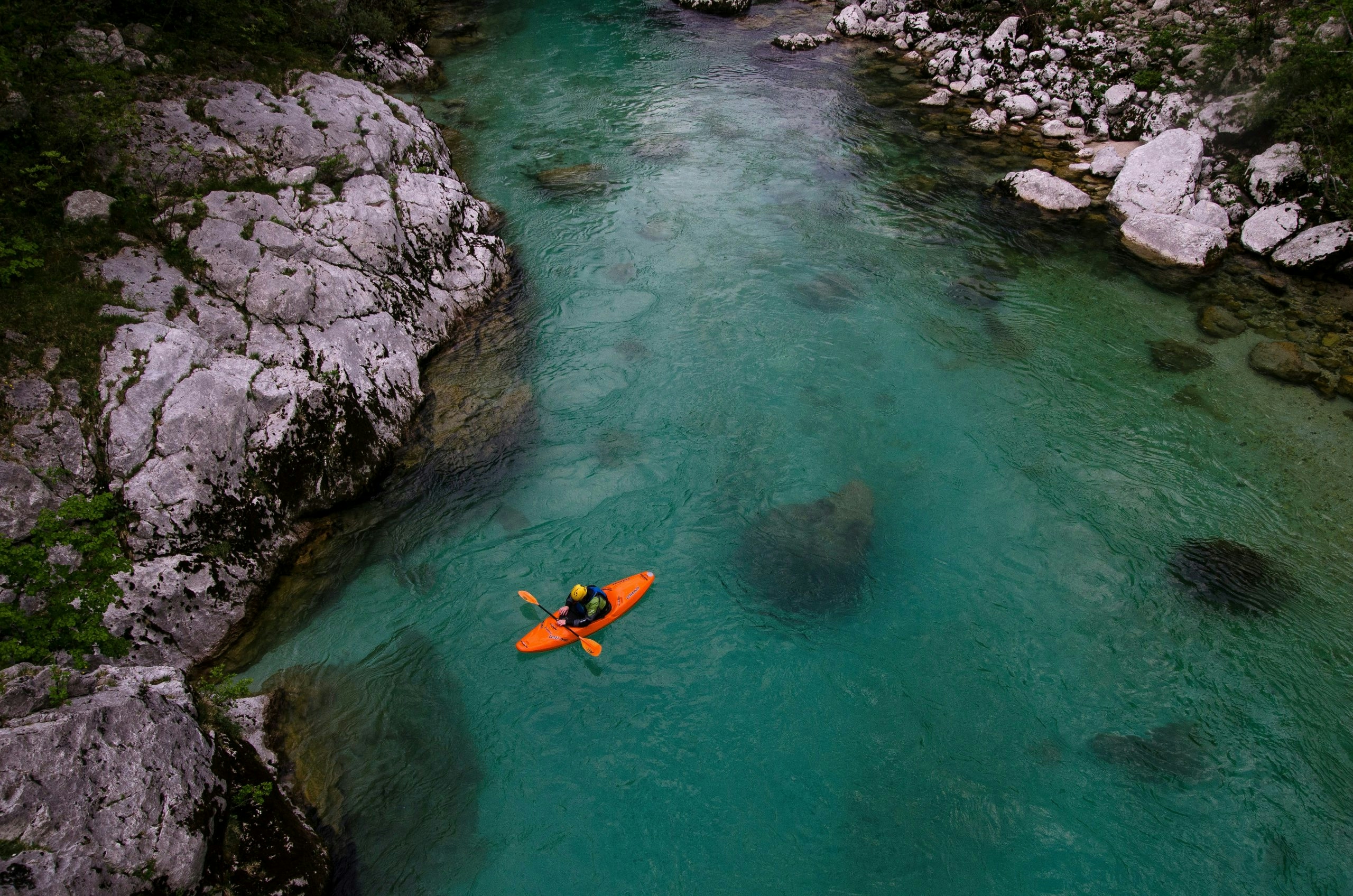 Orange kayak drifting across a peaceful Slovenian lake