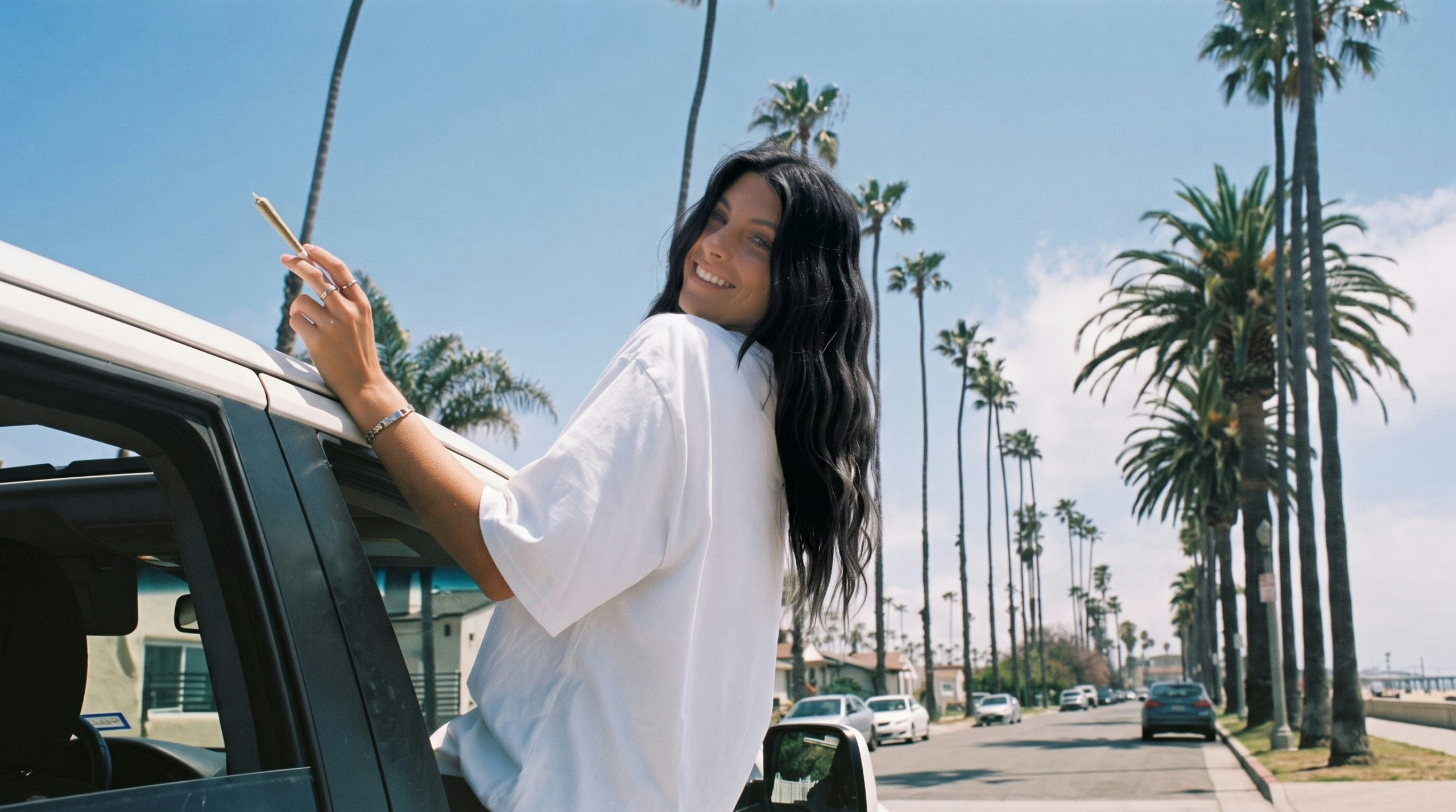 woman leaning out of a car window while holding a joint