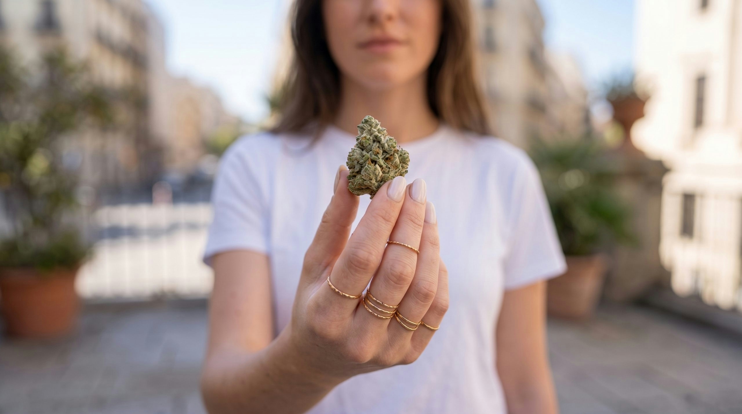 woman holding a cannabis bud on her hand
