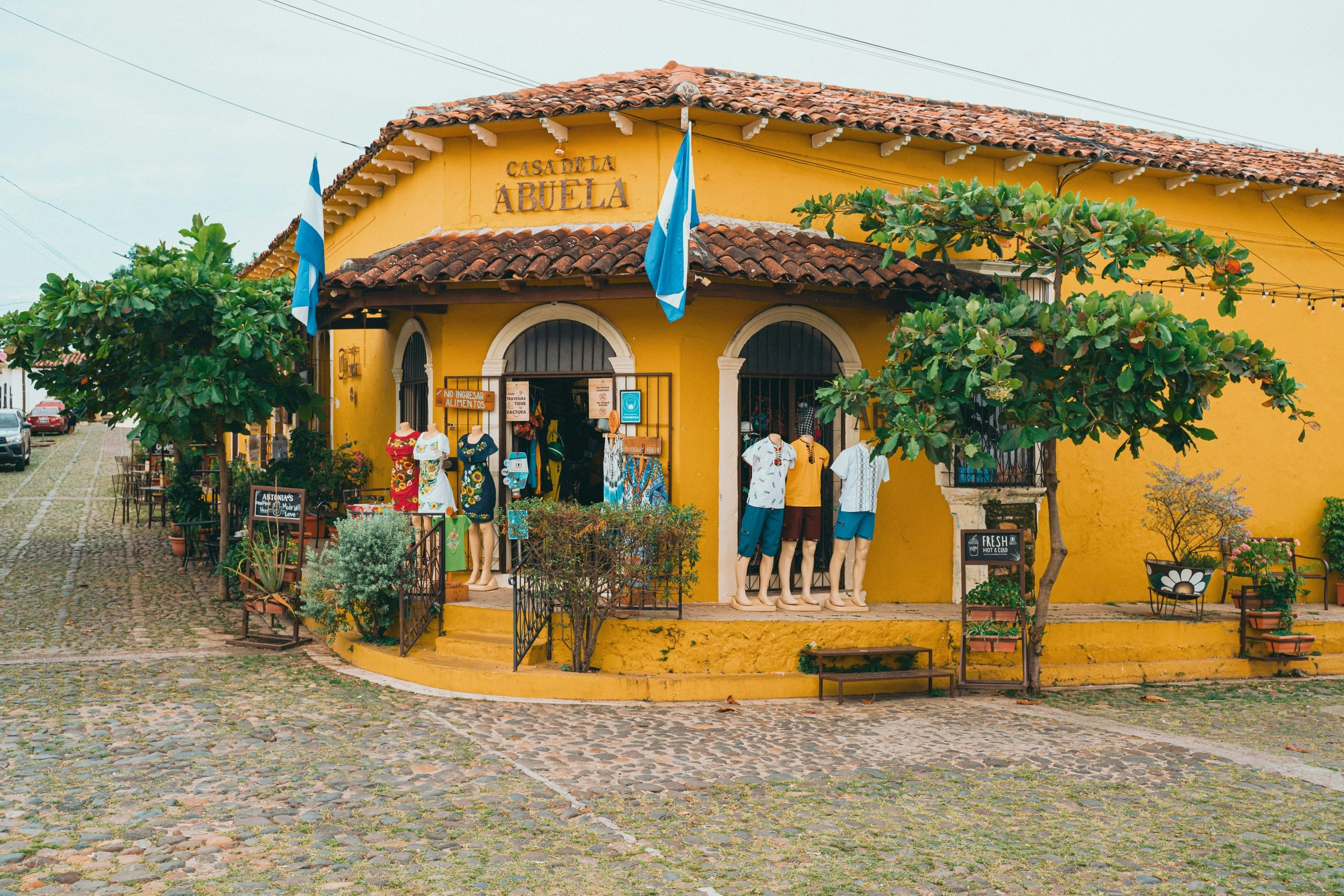 Yellow house with El Salvador flags displayed along the exterior