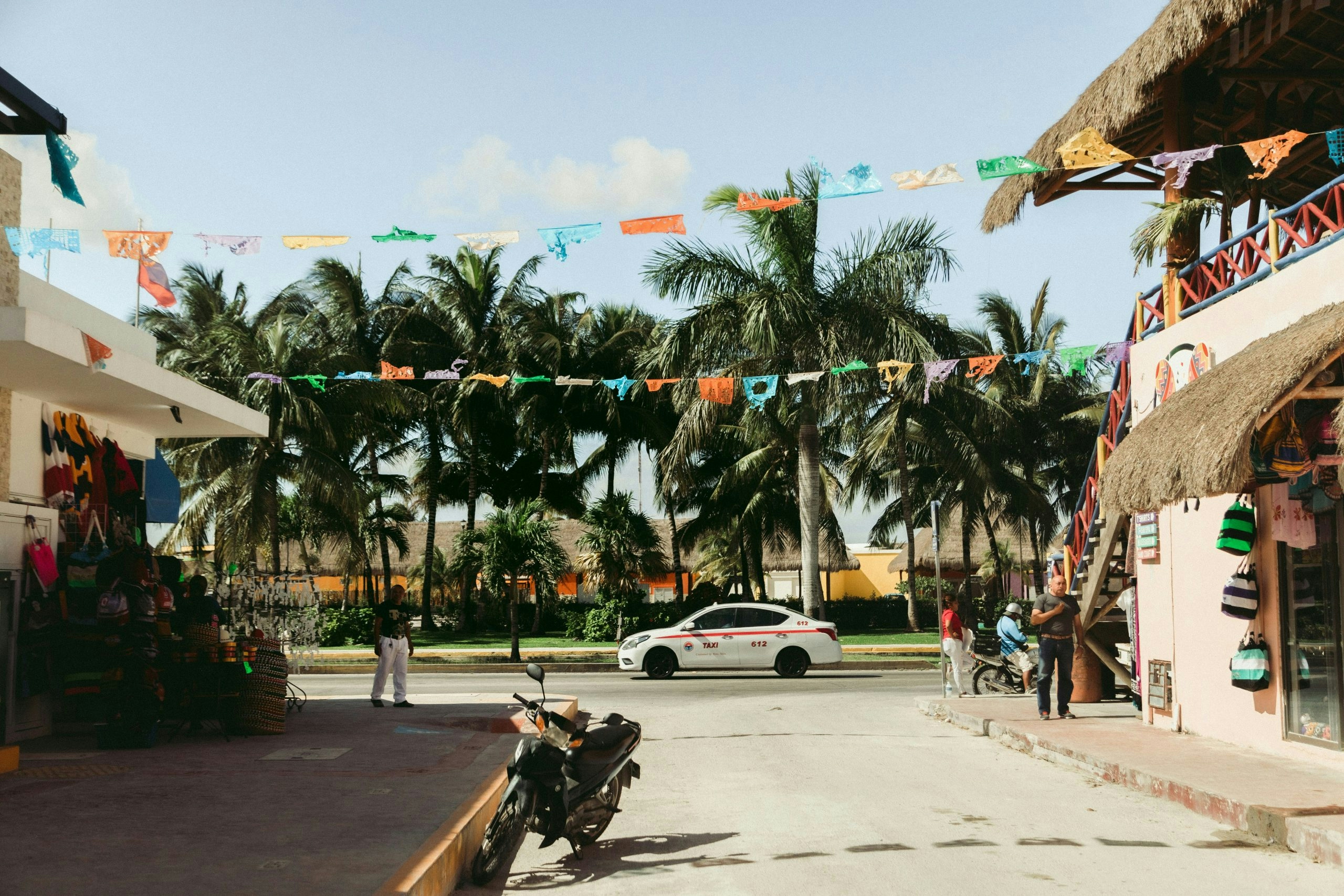 Traditional street in Cozumel lined with colorful buildings and hanging decorative flags