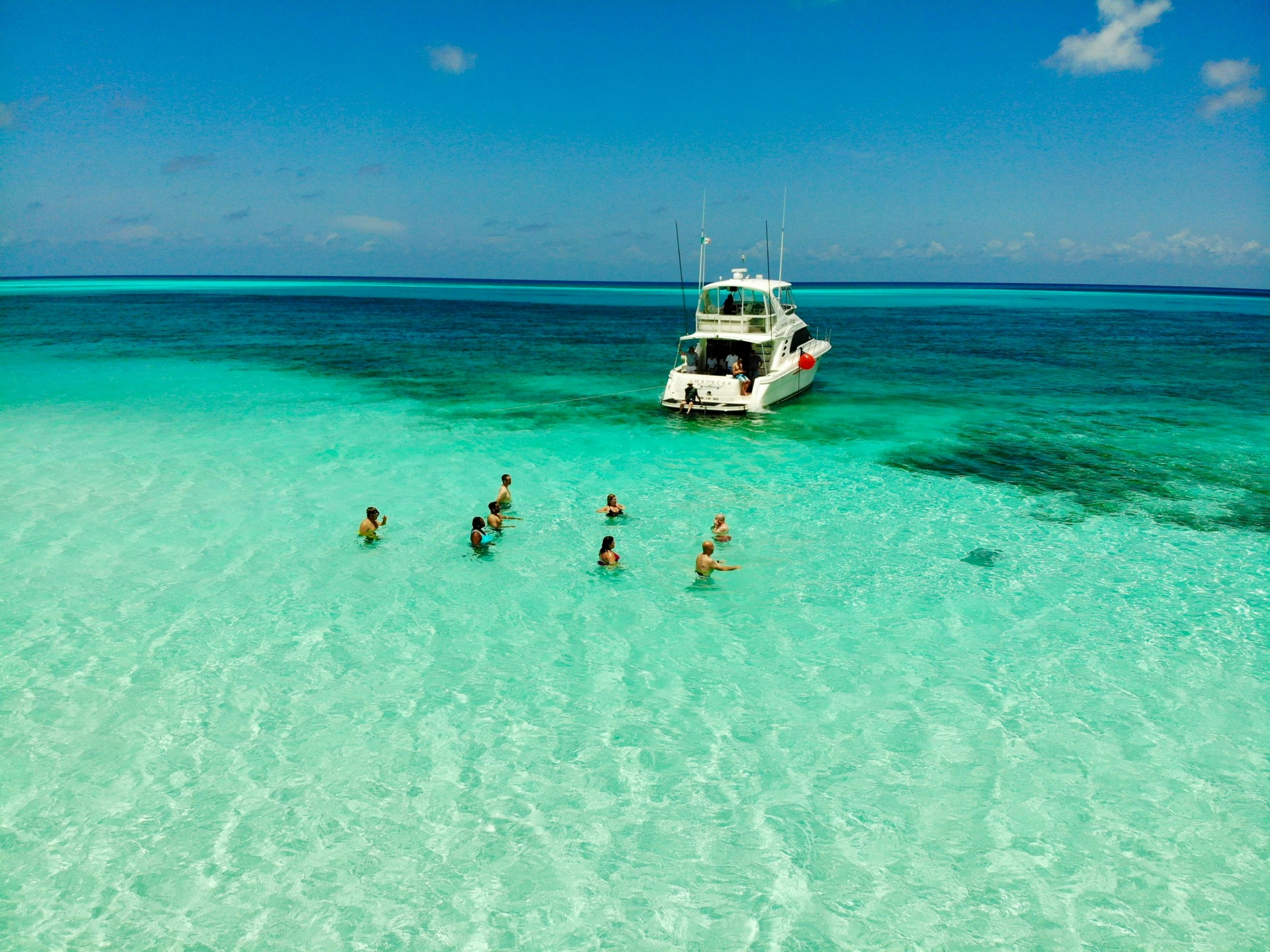 Group of people enjoying the water next to a boat