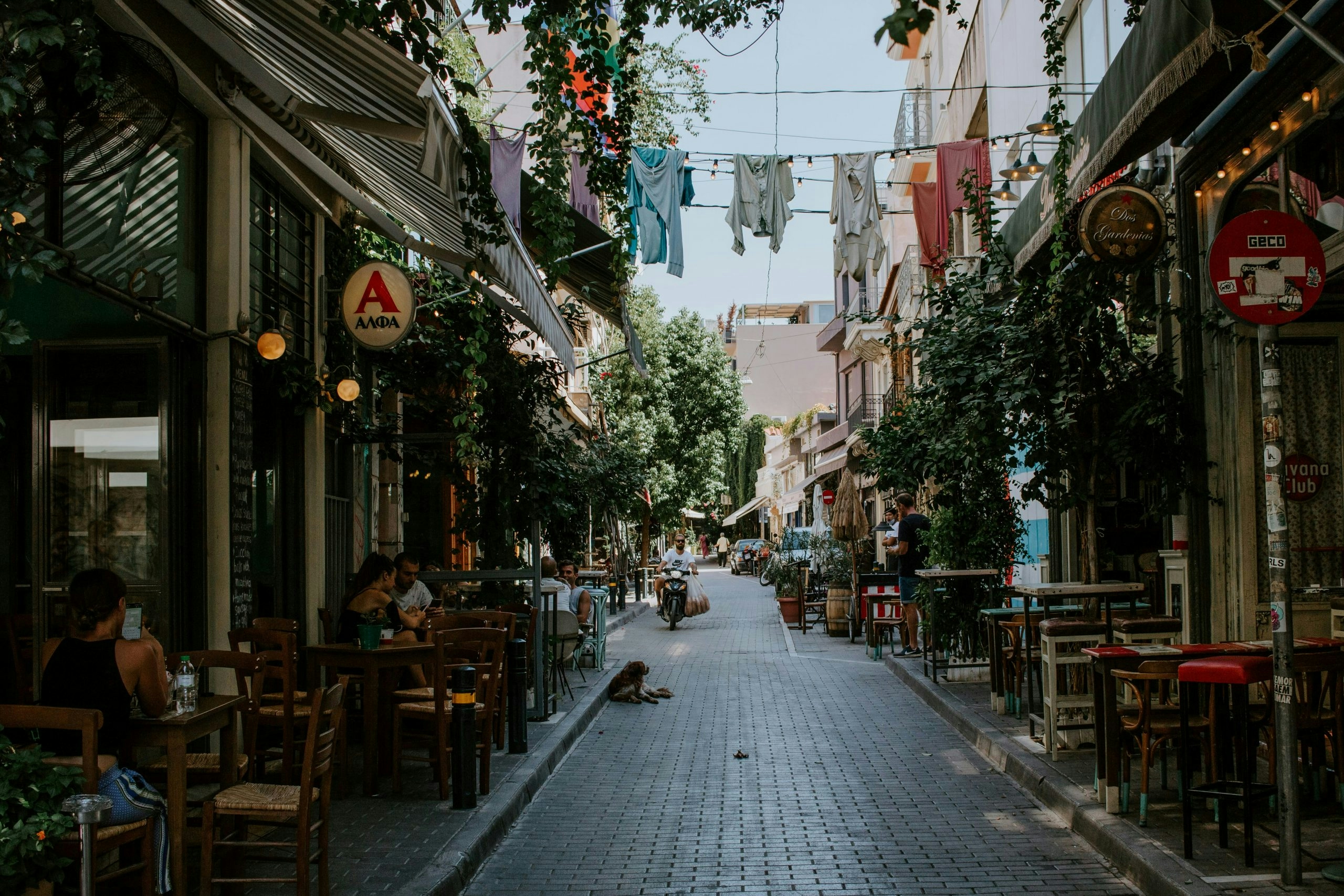 Traditional Athens street with neoclassical buildings, outdoor cafés, and pedestrians
