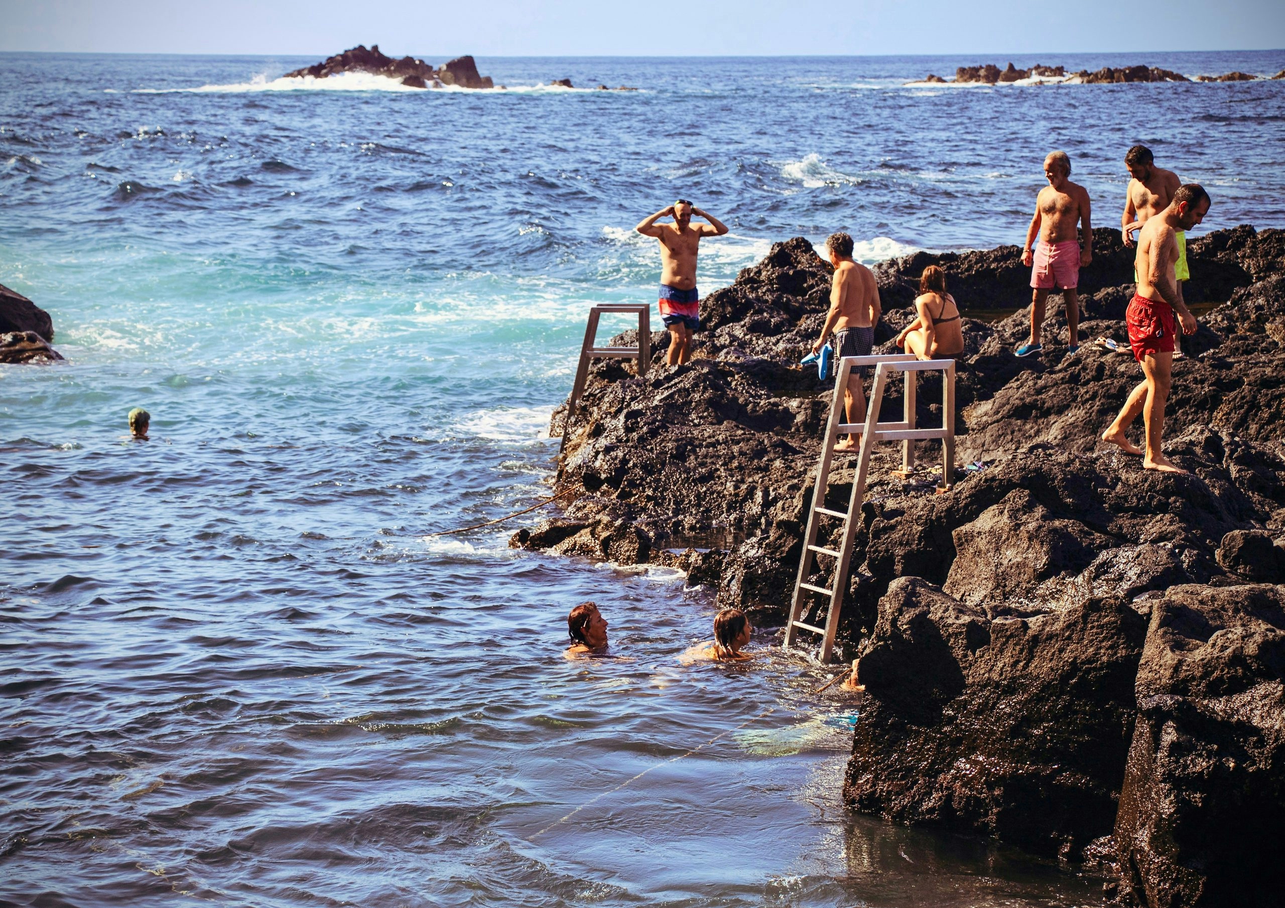 Group of people wading into the sea along the coast