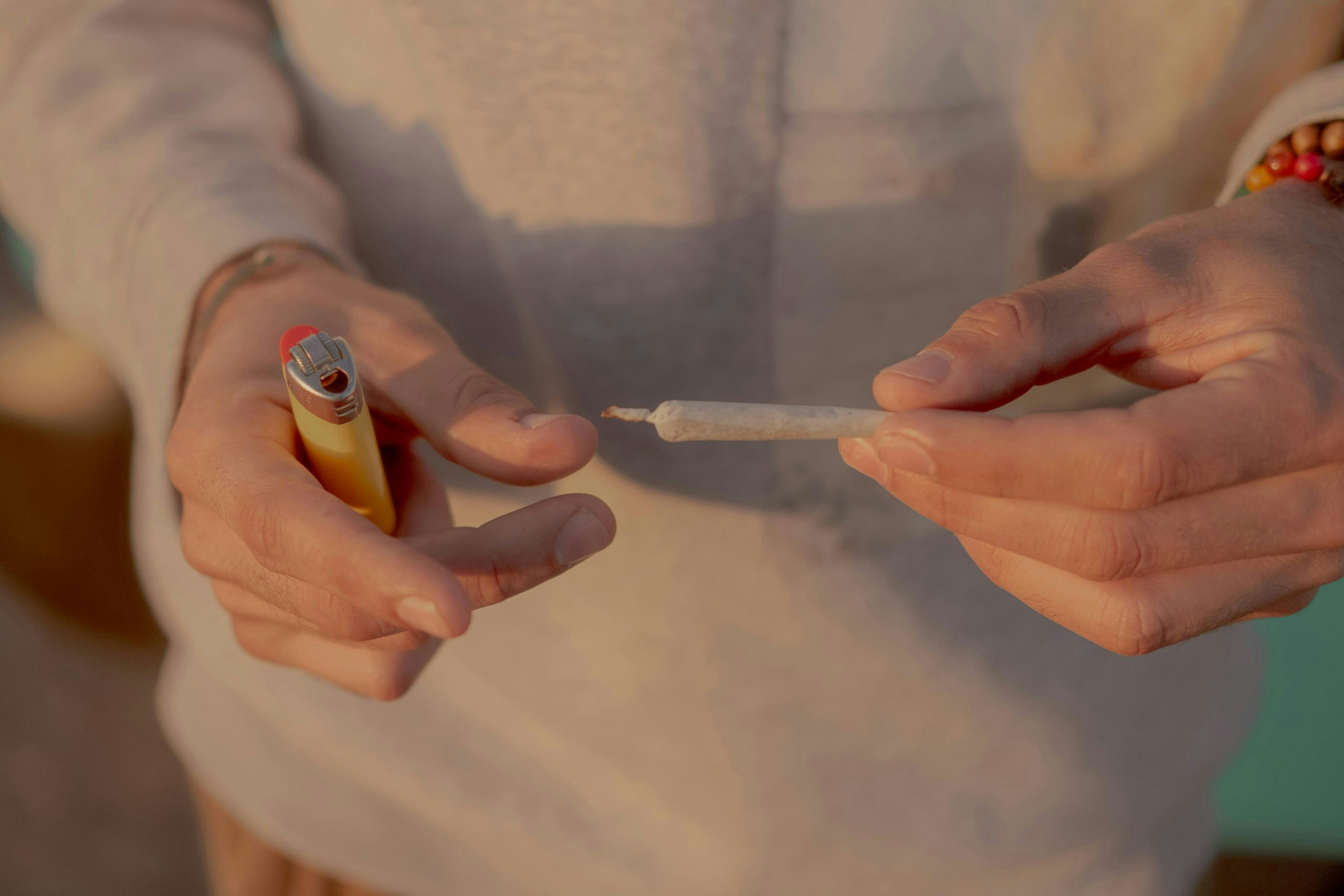 man holding a joint and a lighter